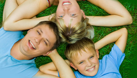 smiling family lying on the grass